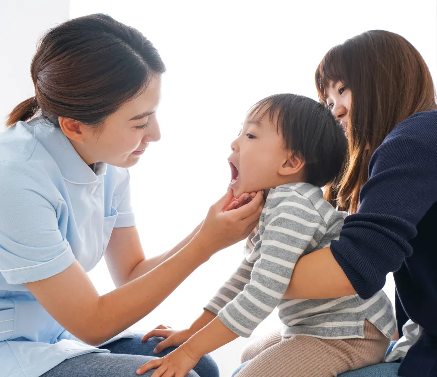 お子さんの口腔内を確認する歯科医師