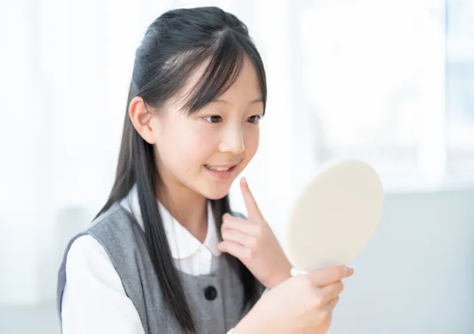 鏡で歯並びを確認する子ども