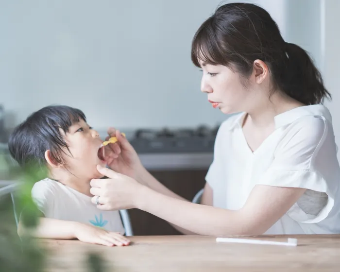 仕上げ磨きを受ける子ども